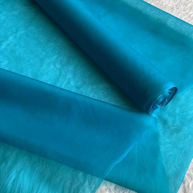 Longan Craft's Multicolor 8 Momme Organza Silk Fabric by the yard—pure mulberry silk for luxury dresses—is partially unrolled and displayed on a textured white background.