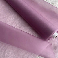 Two rolls of Multicolor 8 Momme Organza Silk Fabric by Longan Craft are unrolled on a white textured surface. This pure mulberry silk fabric is sheer, smooth, and delicate—luxurious material perfect for elegant dresses.