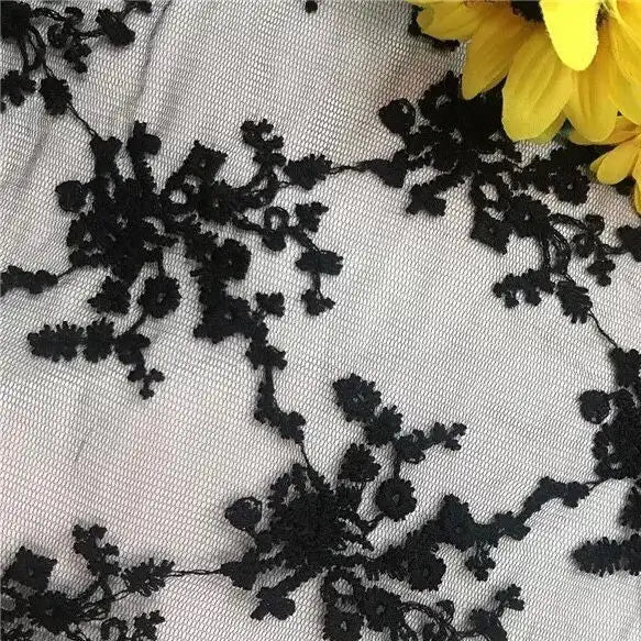 Longan Craft’s Multicolor Embroidered Floral Tulle Fabric by the yard features black lace on a light background with vivid yellow petals, ideal for weddings and crafted from cotton thread embroidery tulle.