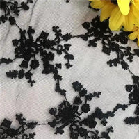 Longan Craft’s Multicolor Embroidered Floral Tulle Fabric by the yard features black lace on a light background with vivid yellow petals, ideal for weddings and crafted from cotton thread embroidery tulle.