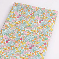 Longan Craft’s Multicolor Fine Cotton Printed Lawn Fabric by the Yard features vibrant pink, yellow, orange, and red flowers with green leaves on white—perfect for creating fresh, lightweight summer clothing.