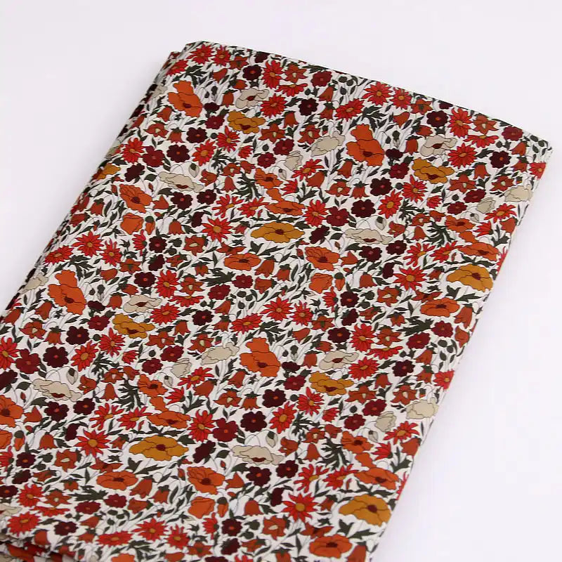 Longan Craft Multicolor Fine Cotton Printed Lawn Fabric by the yard features a lightweight floral print with small red, orange, and white flowers on a light background—ideal for summer lawn clothing.