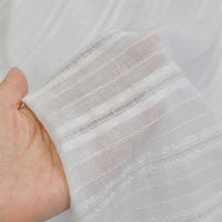 A hand holds up Longan Craft’s Multicolor Leno Dobby Fabric, a pure cotton dobby material with openwork jacquard—lightweight, breathable, and perfect for dresses.