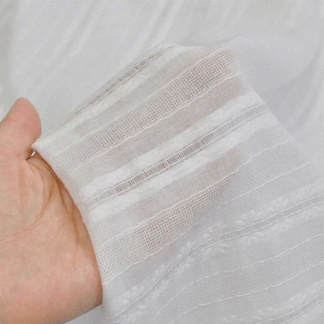 A hand holds up Longan Craft’s Multicolor Leno Dobby Fabric, a pure cotton dobby material with openwork jacquard—lightweight, breathable, and perfect for dresses.