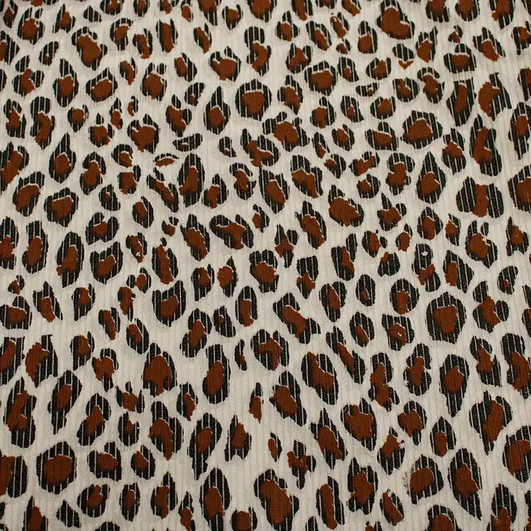 Close-up of Longan Craft's Multicolor Leopard Printed Corduroy Fabric by the yard, featuring irregular black and brown animal spots on soft, light beige polyester corduroy—ideal for apparel.