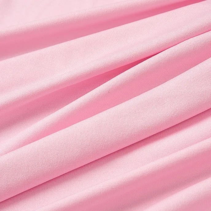 Close-up of Longan Craft’s Multicolor Polyester Jersey Fabric by the yard shows light pink stretchable elastane jersey with soft folds and visible texture, creating gentle diagonal lines across the surface.