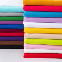 Neatly stacked Multicolor Polyester Jersey Fabric By The Yard from Longan Craft, featuring bright shades like red, yellow, green, and blue; this stretchable elastane jersey is wrinkle-resistant, vibrant, and ideal for practical use.