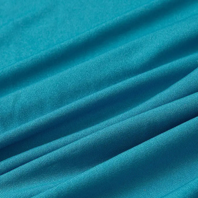 Close-up of Longan Craft Multicolor Polyester Jersey Fabric By The Yard, showing its wrinkle-resistant, stretchable elastane texture in turquoise blue with soft folds and gentle diagonal lines.