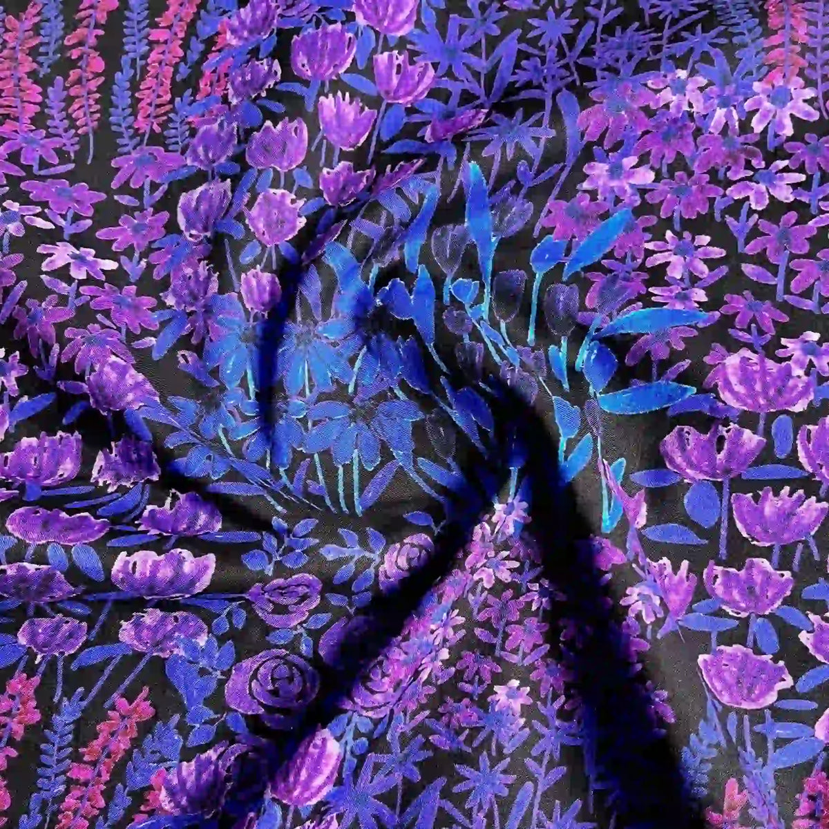A close-up of Longan Craft's Multicolor Printed Lawn Fabric By The Yard shows vibrant purple, blue, and pink floral patterns on soft cotton lawn cloth material with a dark background. Ideal for sewing and crafts.