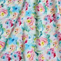 Longan Craft's Multicolor Printed Lawn Fabric by the Yard features a watercolor-style floral design in pink, yellow, and blue with green leaves on white pure cotton; the soft, slightly wrinkled lawn adds subtle shadows and texture.