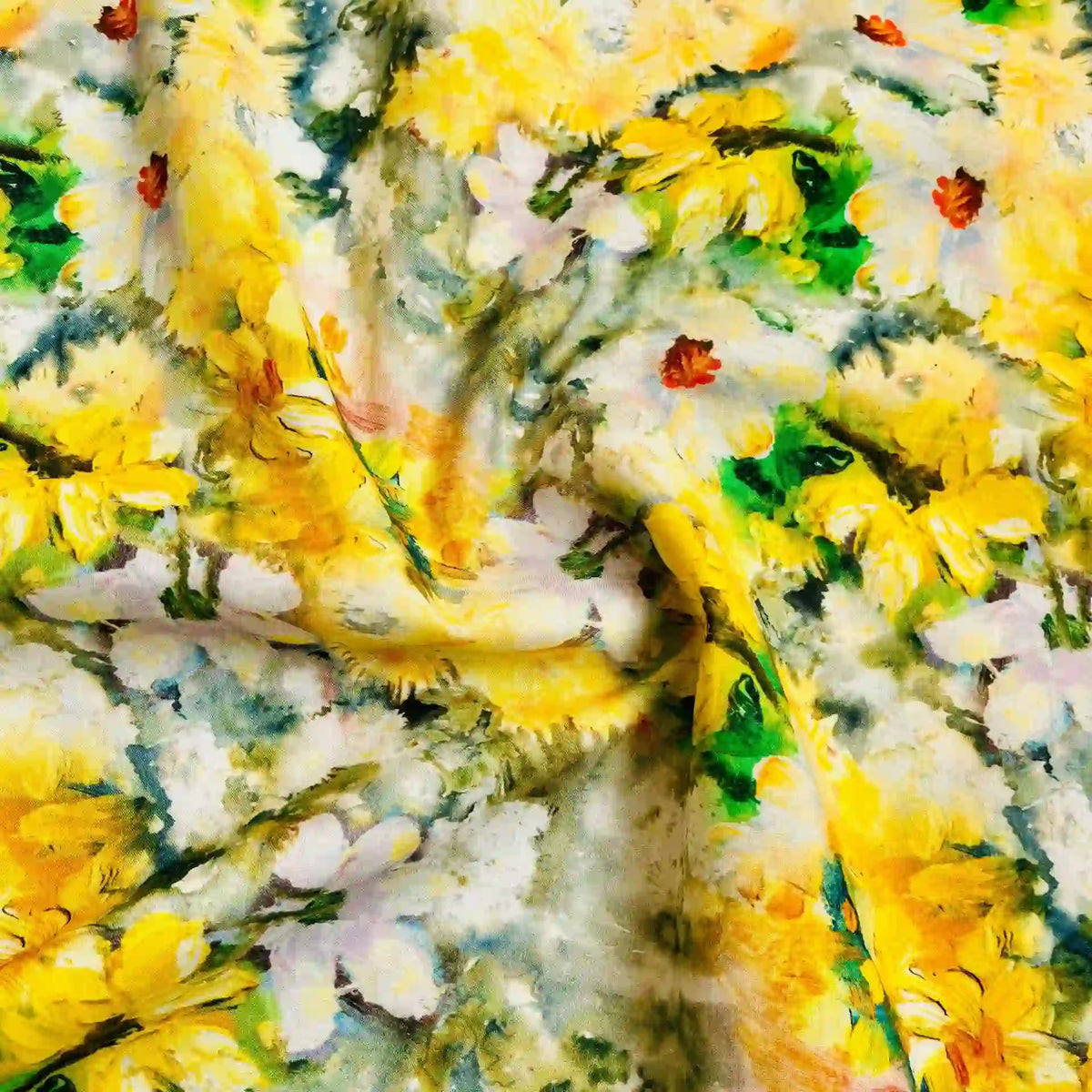 A close-up of Longan Craft’s multicolor printed floral cotton lawn fabric by the yard, with yellow and white flowers, green leaves, and orange accents on a soft, slightly crumpled textured surface.