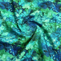 A close-up of Longan Craft’s Multicolor Printed Lawn Fabric By The Yard shows its soft, pure cotton with a vibrant blue, green, and teal floral design. The slightly wrinkled texture adds depth and character to this floral cotton lawn material.