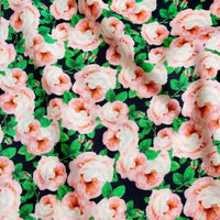Longan Craft’s Multicolor Printed Lawn Fabric By The Yard features soft cotton with light pink roses and green leaves on a dark base—a vibrant floral print ideal for standout clothing or décor.