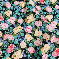 Longan Craft’s Multicolor Printed Lawn Fabric By The Yard features pink and yellow roses, green leaves, and purple flowers on a dark background—a vibrant floral design on soft cotton lawn for your creative projects.