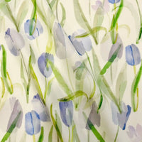 The Longan Craft Multicolor Printed Lawn Fabric by the yard features soft watercolor-style purple and blue tulips with green stems on white cotton, creating a gentle and airy floral design in this premium lawn cloth material.