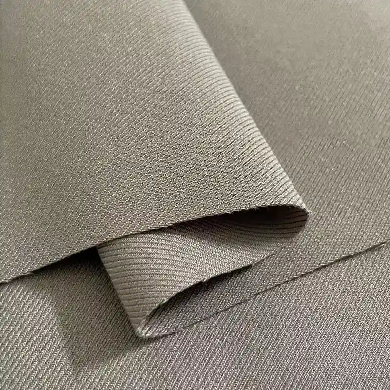 Close-up of Longan Craft’s Multicolor Rayon Gabardine Fabric by the yard, a stretch viscose twill gabardine textile with a fine diagonal ribbed texture, featuring a neatly folded section atop a flat piece—ideal for custom uniforms.