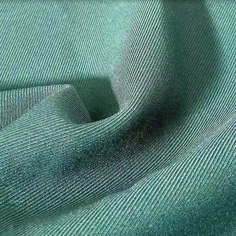 A close-up of Longan Craft's Multicolor Rayon Gabardine Fabric By The Yard shows fine diagonal ridges and a smooth, slightly wavy texture—this stretch viscose twill gabardine is versatile for custom uniforms.