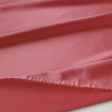 A close-up of Multicolor Satin Fabric By The Yard from Longan Craft, featuring silky polyester satin cloth with a slightly frayed edge and gentle folds that create highlights and shadows—perfect for apparel.
