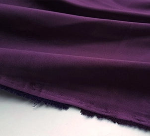 A close-up of Longan Craft's Multicolor Satin Fabric by the Yard shows its silky polyester satin texture and unfinished edge, laid out with soft folds on a light surface—ideal for stylish apparel projects.