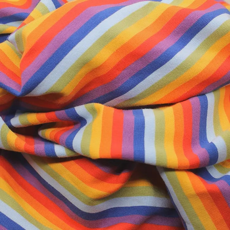 A close-up of Longan Craft's Multicolor Striped Cotton French Terry Fabric by the yard shows its stretch knit, featuring horizontal orange, yellow, red, purple, and light blue stripes for a vibrant and playful look—perfect for sweatshirts.
