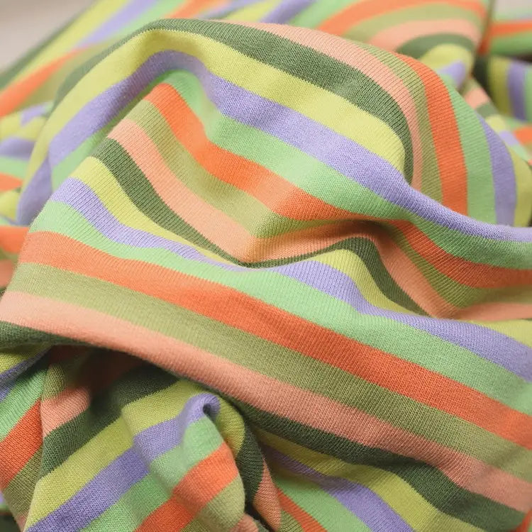 A close-up of Longan Craft Multicolor Striped Cotton French Terry Fabric by the yard, featuring soft, crumpled stretch knit with horizontal pastel orange, green, lavender, and peach stripes—ideal for cozy sweatshirts.