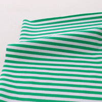 A close-up of Multicolor Striped Cotton Jersey Fabric by the yard from Longan Craft, featuring green and white horizontal stripes with stretch elastane, slightly folded on a light surface.