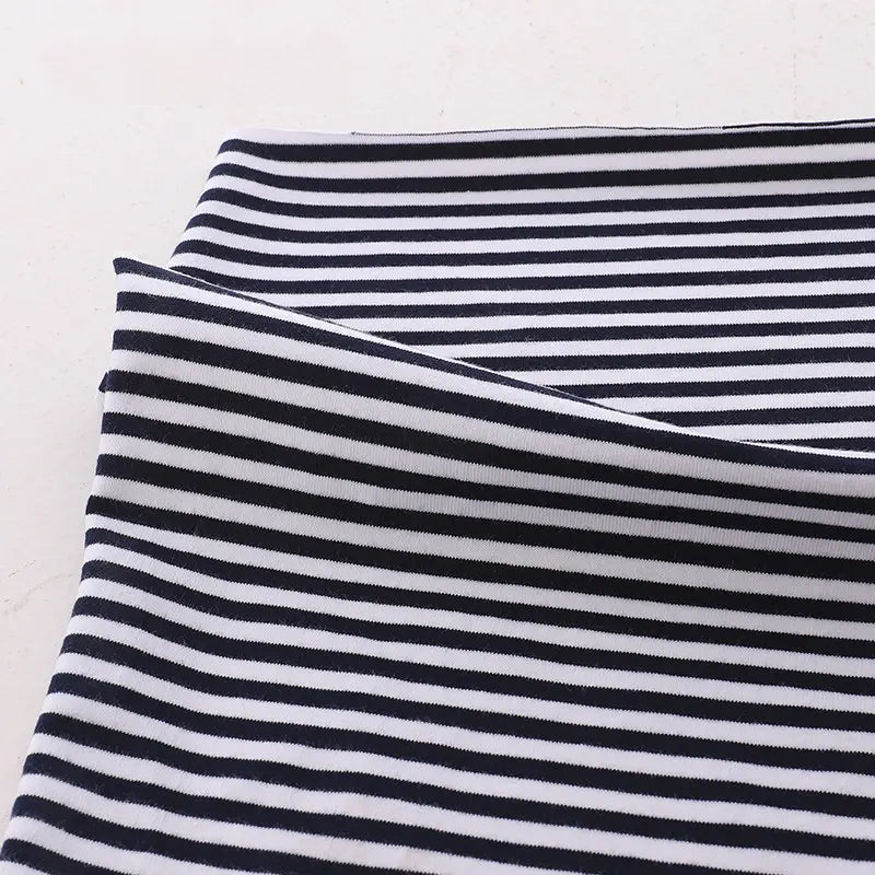 A close-up of Longan Craft's Multicolor Striped Cotton Jersey Fabric by the yard, stretch elastane sports jersey material, neatly folded on a light surface.