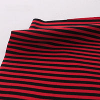 A close-up of Longan Craft's Multicolor Striped Cotton Jersey Fabric by the yard, featuring red and black stripes on stretchy elastane jersey. Perfect for activewear thanks to its comfort and softness.