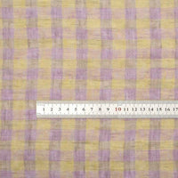 A Longan Craft Multicolor Washed Plaid Linen Fabric By The Yard is displayed beneath a ruler measuring about 15 centimeters across. This vintage checkered pure linen material features a soft, textured appearance with a subtle yellow and purple grid pattern and is ideal for breathable casual wear.