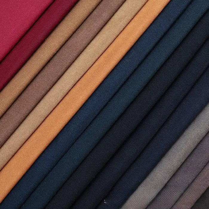 A close-up of neatly stacked Longan Craft Multicolor Waxed Cotton Canvas Fabric by the yard in red, brown, tan, navy blue, and gray—100% cotton waterproof material perfect for outdoor clothing—arranged diagonally.