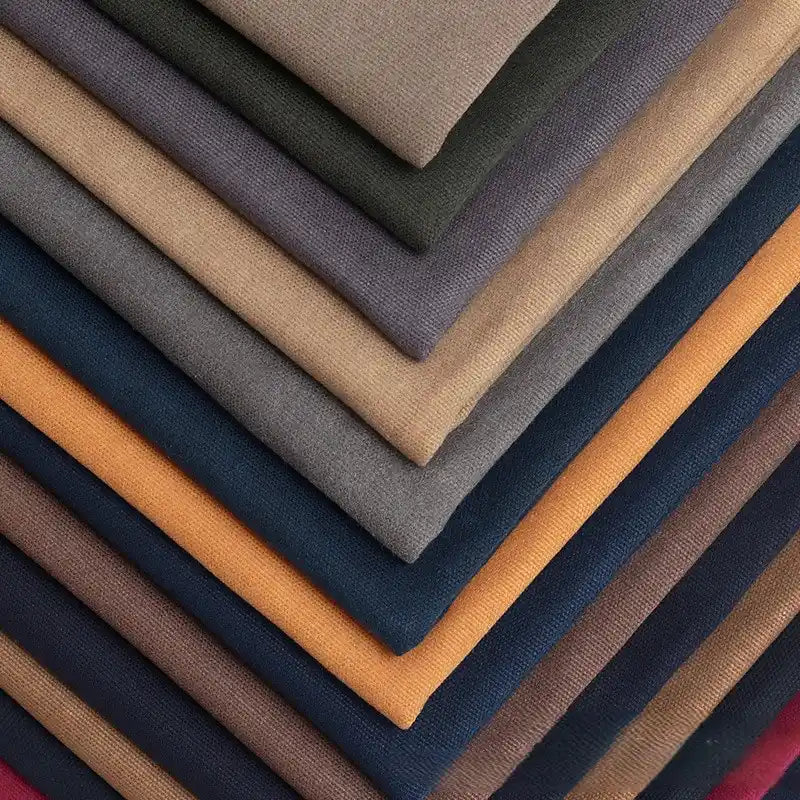A diagonal stack of Longan Craft’s Multicolor Waxed Cotton Canvas by the yard shows solid brown, beige, gray, blue, orange, and burgundy waterproof cotton fabric—moisture-proof and ideal for outdoor clothing.