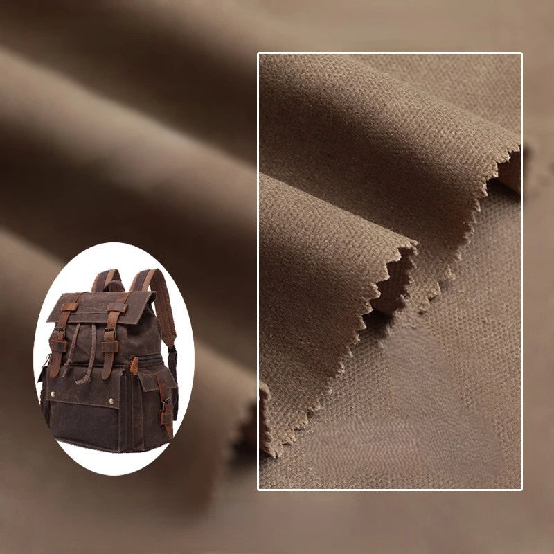 Close-up of Longan Craft Multicolor Waxed Cotton Canvas Fabric with zigzag-cut edges, shown next to a small brown backpack. This 100% waterproof, moisture-proof fabric is perfect for outdoor clothing and is sold by the yard.