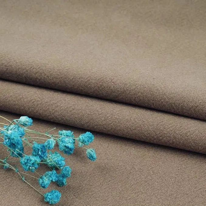 A close-up of Longan Craft's Multiple Colors Linen Fabric By The Yard, a durable washed cotton linen blend for apparel, shown in brown with bright blue dried flowers on top, highlighting the contrast between earthy and vibrant tones.