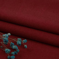 Folded Longan Craft Multiple Colors Linen Fabric By The Yard, a washed cotton linen blend with a matte finish, is displayed with small blue dried flowers in the lower left corner.