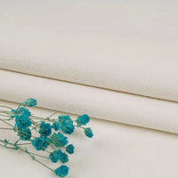 Turquoise dried flowers rest on neatly folded Longan Craft Multiple Colors Linen Fabric by the yard, highlighting the breathable washed cotton linen blend for durable, elegant apparel against a neutral background.