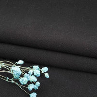 A close-up of Longan Craft's Multiple Colors Linen Fabric By The Yard, a durable washed cotton linen blend for apparel, with light blue dried flowers resting on the breathable material.