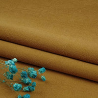 A close-up of Longan Craft’s Multiple Colors Linen Fabric By The Yard—a washed cotton linen blend—shows its durable, breathable fibers, folded neatly with a small bunch of blue dried flowers on top.