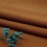 A folded piece of Longan Craft’s Multiple Colors Linen Fabric By The Yard, made from a soft washed cotton-linen blend, is shown with bright blue dried flowers resting on it in the lower left corner.