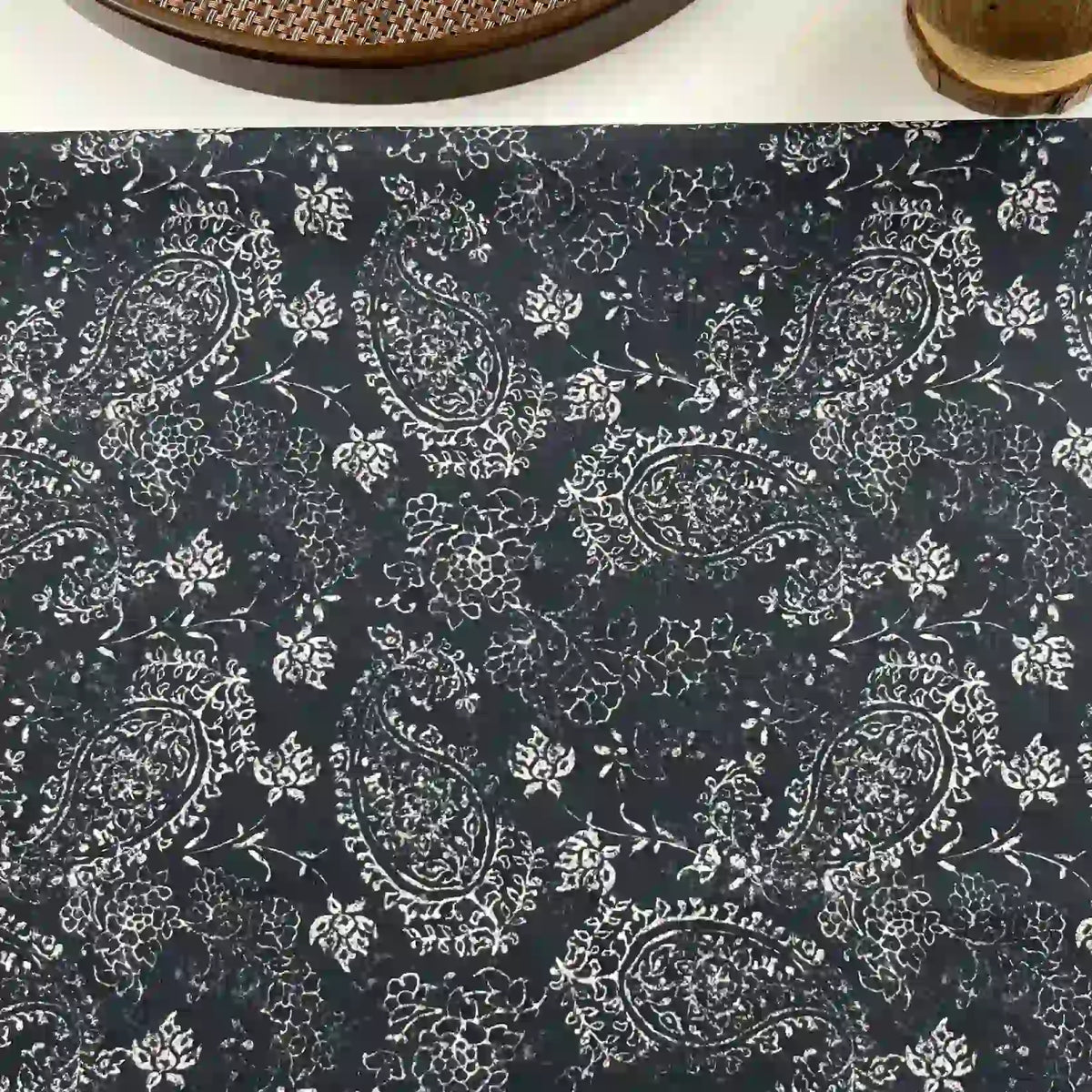 Longan Craft's Paisley Printed Voile Fabric By The Yard is a pure cotton material in dark blue with a white paisley and floral pattern, perfect for shirts. A woven tray and cup appear at the edge of the image.