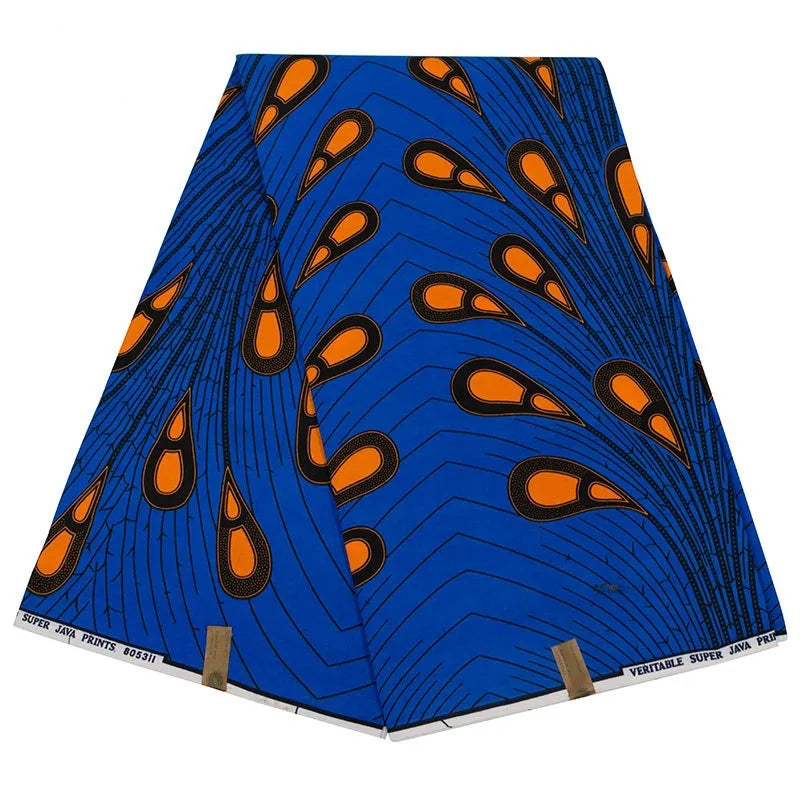A folded piece of vibrant blue Peacock Feather Printed Ankara fabric from Longan Craft, made of pure cotton with orange and black teardrop patterns and wavy lines, labeled "Veritable Java Prints" along the edge.