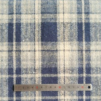 A Longan Craft metal ruler measures about 16 cm on Plaid Brushed Mammoth Flannel Fabric By The Yard, a comfy polyester cotton material with intersecting blue and off-white lines—perfect for cozy fall projects.