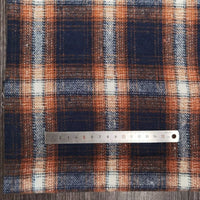 The Longan Craft Plaid Brushed Mammoth Flannel Fabric by the yard, a blue, orange, and white polyester-cotton blend, is displayed on wood with a metal ruler showing about 15 cm across the comfy fall flannel surface.