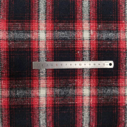 A silver ruler lies across Longan Craft Plaid Brushed Mammoth Flannel Fabric By The Yard, measuring 0–15 cm on colorful polyester cotton flannel with a classic tartan pattern—perfect comfy fall material.