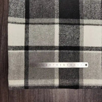 A metal 15cm ruler lies on Longan Craft Plaid Brushed Mammoth Flannel Fabric—a comfy, colorful polyester-cotton flannel—spread across a wooden surface.