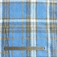 A metal ruler marked in red and black centimeters (up to 15 cm) lies on Longan Craft’s Plaid Brushed Mammoth Flannel Fabric, a colorful polyester cotton flannel sold by the yard as comfy fall material.