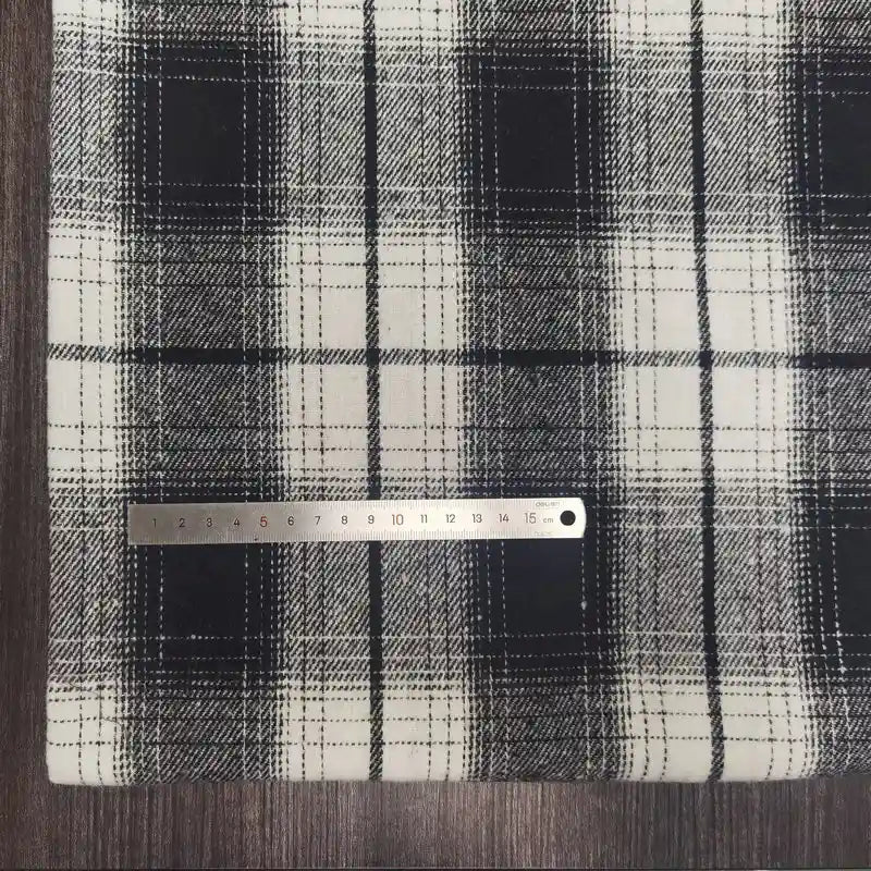 A Plaid Brushed Mammoth Flannel Fabric by Longan Craft is laid flat, with a metal ruler measuring about 15 cm placed horizontally across the colorful polyester cotton flannel near the left side.