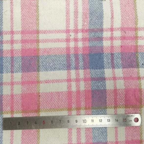A metal ruler measures the plaid pattern on Longan Craft's Plaid Brushed Mammoth Flannel Fabric by the Yard, showing soft checks about 5 cm wide. This colorful polyester-cotton flannel offers a cozy, comfy texture perfect for fall.