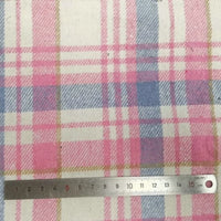 A metal ruler measures the plaid pattern on Longan Craft's Plaid Brushed Mammoth Flannel Fabric by the Yard, showing soft checks about 5 cm wide. This colorful polyester-cotton flannel offers a cozy, comfy texture perfect for fall.