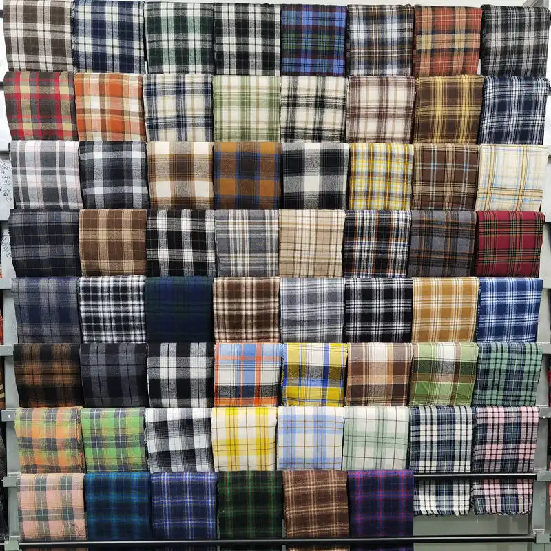 Longan Craft's Plaid Brushed Mammoth Flannel Fabric by the yard features colorful polyester-cotton blends in cozy checkered designs, neatly stacked to showcase a wide variety of comfy fall flannels.