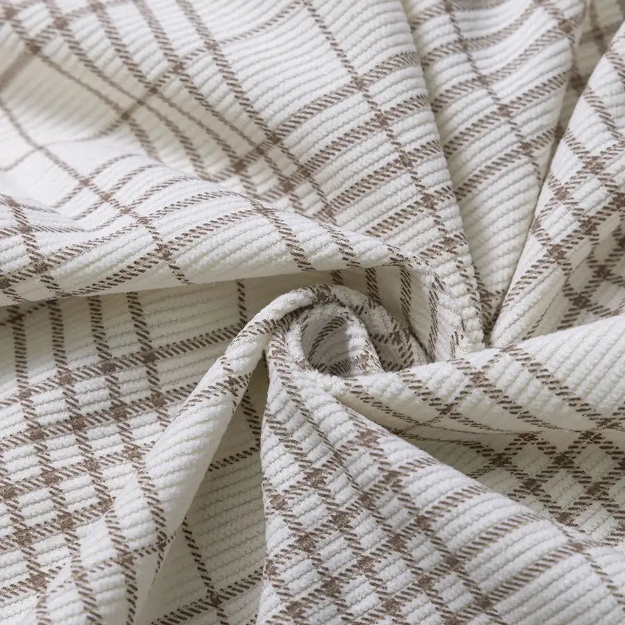 Close-up of Longan Craft’s Plaid Print 16 Wale Corduroy Fabric By The Yard, featuring colorful fine wale corduroy with a brown plaid pattern, gently folded and twisted at the center to showcase its premium texture and weave—ideal for sewing cozy pants or your next creative project.